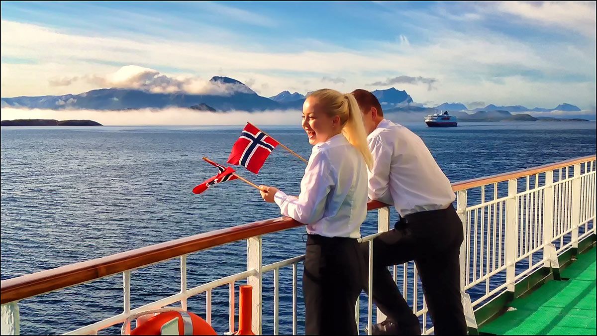 Norwegian coastal voyage - people with Norway flags on a boat